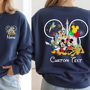 May include: Navy blue sweatshirt featuring a Disney-themed design. The front displays a Mickey Mouse ear outline with Disney characters and the word "Name". The back showcases a larger design with characters, fireworks, and the text "Custom Text".