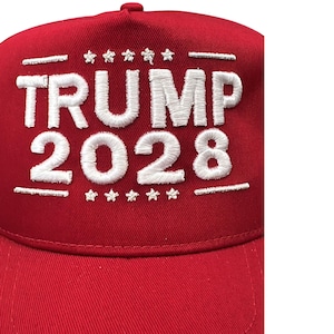 May include: Red baseball cap with white embroidered text that reads "TRUMP 2028" with stars above and below the text.