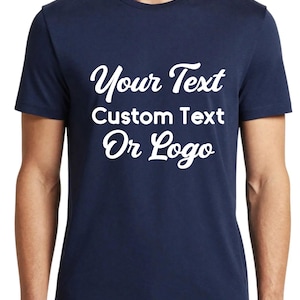 Op de afbeelding: Een marineblauw T-shirt met korte mouwen en witte tekst op de borst met de tekst "Your Text Custom Text Or Logo" in een combinatie van script- en schreefloze lettertypes. Het kledingstuk heeft een ronde hals en een standaard pasvorm.