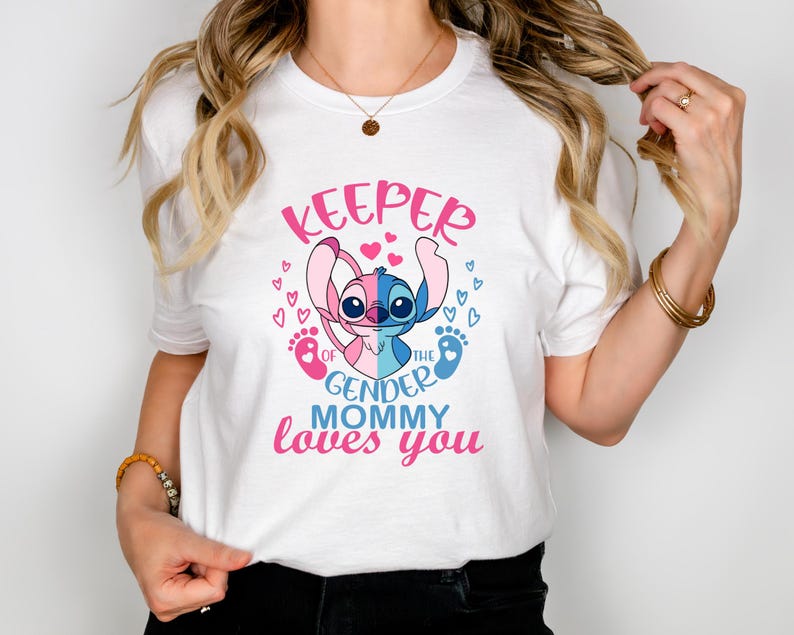 Puede incluir: Camiseta blanca con un personaje de Stitch azul y rosa sosteniendo una huella de pie de beb&eacute; rosa y azul. El texto en la camiseta dice "Keeper of the gender mommy loves you".