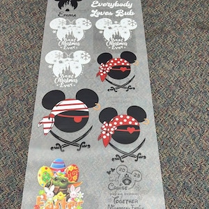 Peut inclure: Une feuille de divers motifs sur le th&egrave;me de Disney pour l'artisanat. Les motifs comprennent des silhouettes de Mickey Mouse avec des noms, des personnages sur le th&egrave;me des pirates, des graphiques de P&acirc;ques et du texte sur le th&egrave;me des croisi&egrave;res. Les motifs sont en noir et blanc, avec quelques accents de rouge et d'autres couleurs.