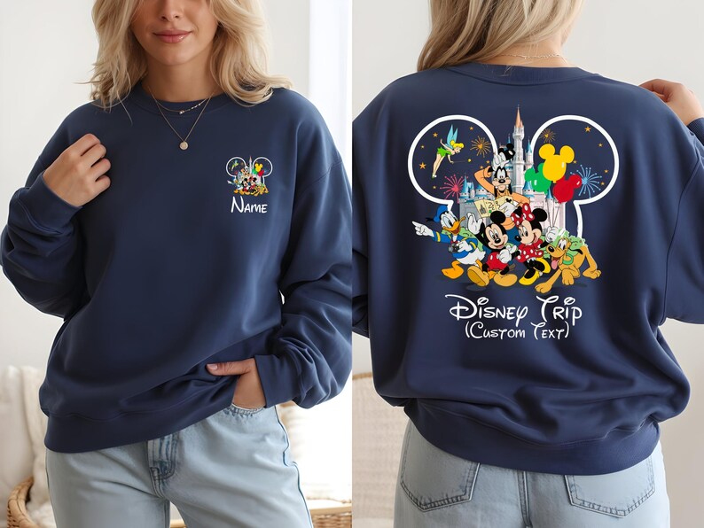 May include: Navy blue sweatshirt featuring Disney characters. The front displays a small Mickey Mouse head design with characters and the name "Name". The back showcases a larger Mickey Mouse head with Disney characters, a castle, and the text "Disney Trip (Custom Text)".