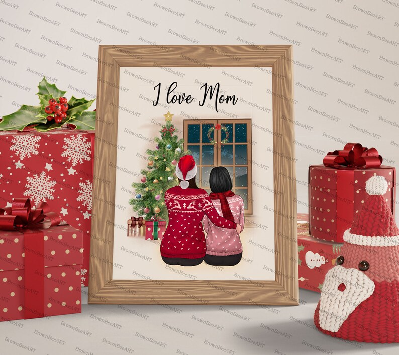 May include: A framed illustration of two people in red and pink sweaters standing in front of a Christmas tree and a window with a snowy scene. The text "I love Mom" is written above the people.