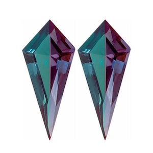 May include: Two kite-shaped gemstones with a colour gradient from teal to purple. The gems are faceted, catching the light. They are set against a white background, emphasising their colour and cut.