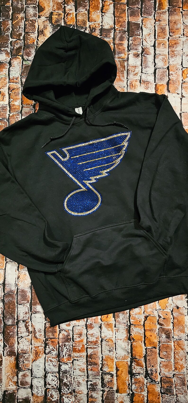 May include: Black hoodie with a blue and gold rhinestone St. Louis Blues logo.