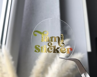 May include: A clear round sticker with the text "Family Sticker" in gold foil lettering.