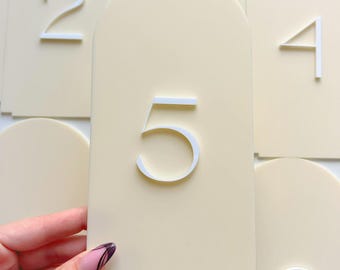 Número de mesa de boda de acrílico color beige con forma de arco, número de mesa en crema y blanco, número de mesa con forma de arco, número de mesa moderno, decoración de mesa elegante en blanco roto.