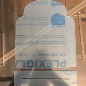 May include: A clear plastic sheet with the text "PLEXIGLAS" and "THE ORIGINAL BY R&Ouml;HM" printed on it. The sheet also has the text "30 YEARS GUARANTEE NO VELLOWING" printed on it.