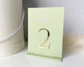 Może przedstawiać: Jasnozielona karta numeru stołu z napisem "TABLE" i numerem "2" w kolorze złotym.