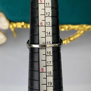 Op de afbeelding: Een zilveren ring op een ringmaat, die de ringmaat 16 aangeeft.