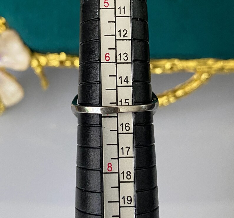 Op de afbeelding: Een zilveren ring op een ringmaat, die de ringmaat 16 aangeeft.