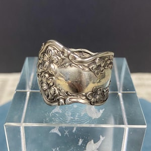 May include: A silver ring made from a repurposed spoon with a floral design.