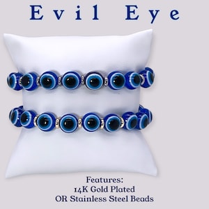 Puede incluir: Dos pulseras azules de ojo turco con detalles blancos y negros. La pulsera superior tiene cuentas plateadas, y la pulsera inferior tiene cuentas doradas. Características: chapado en oro de 14 quilates O cuentas de acero inoxidable.