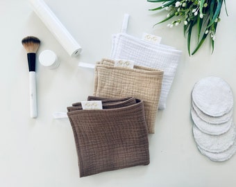 May include: Three reusable makeup remover cloths in white, beige, and brown with the text "Ko-Ko" on each. The cloths are made of a soft, textured fabric. There are also five white cotton rounds on a white surface.