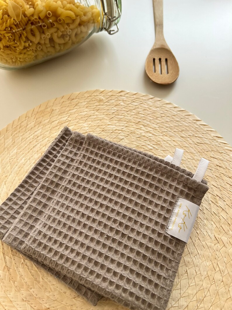 In this photo are caramel color kitchen towel laying on lunch table.