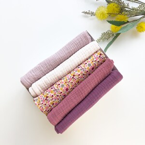 Peut inclure: Un lot de cinq langes en mousseline douce pour b&eacute;b&eacute;, dans une vari&eacute;t&eacute; de couleurs, dont le rose, le violet et le blanc avec un imprim&eacute; floral. Les langes sont pli&eacute;s et dispos&eacute;s dans une bo&icirc;te.