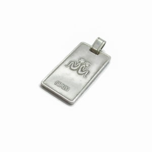 Puede incluir: Encanto de colgante de plata con un s&iacute;mbolo del zod&iacute;aco G&eacute;minis y la palabra "G&eacute;minis" grabada en la parte delantera.
