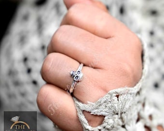 Puede incluir: Un anillo de plata con forma de calavera con un diseño detallado. El anillo se lleva en un dedo.