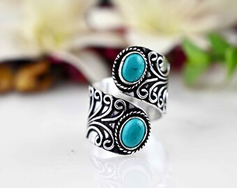 Peut inclure: Une bague en argent avec une pierre turquoise sertie dans un motif en spirale. La bague est ouverte et réglable.