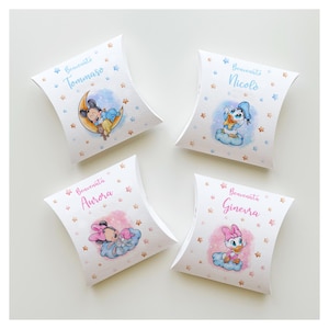 Può includere: Quattro scatole a cuscino bianche con illustrazioni di personaggi Disney. Ogni scatola presenta un personaggio diverso: Topolino, Paperino, Minnie e Paperina. Le scatole hanno testo in italiano, con stelle e nuvole.