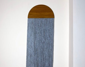 May include: A gray yarn wall hanging with a half-circle wooden top.
