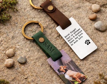 May include: Two personalized keychains with leather straps and metal rings. One keychain features a dog photo, the other has text that reads "Never forget that in between Hello & Goodbye there was Love. So much Love." The keychains are on a stone surface.