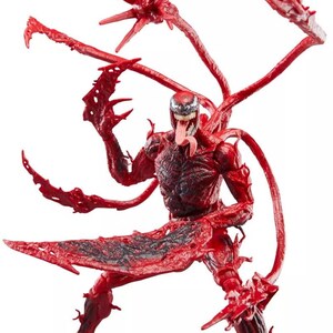May include: A red and black action figure of the Marvel Comics character Carnage. The figure has multiple tendrils and blade-like appendages. The figure is in a dynamic pose with its tongue extended.