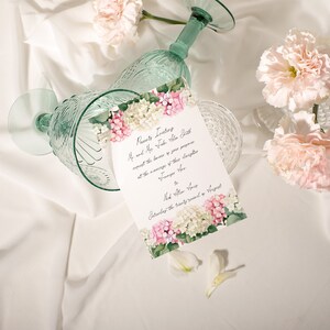May include: A wedding invitation with pink and white flowers on a white background. The invitation reads "Parents Request the Honor of Your Presence at the marriage of their daughter..."