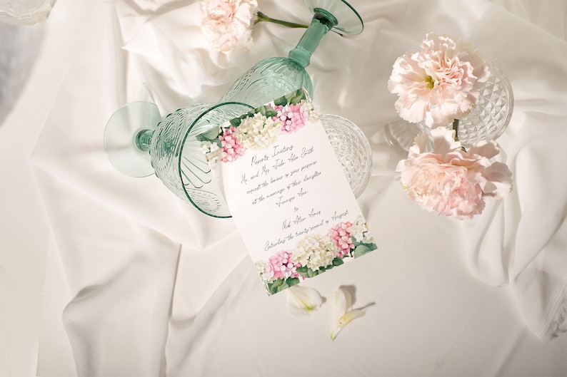 May include: A wedding invitation with pink and white flowers on a white background. The invitation reads "Parents Request the Honor of Your Presence at the marriage of their daughter..."