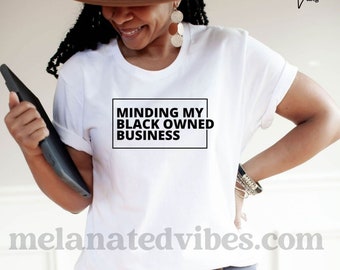 May include: A white t-shirt with the text "Minding My Black Owned Business" in a black box.
