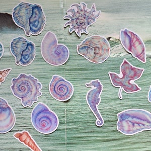 May include: A collection of watercolour stickers depicting marine life, including shells and a seahorse, in shades of blue, purple, and pink. The stickers are arranged on a green and blue background, with a bottle containing coral.