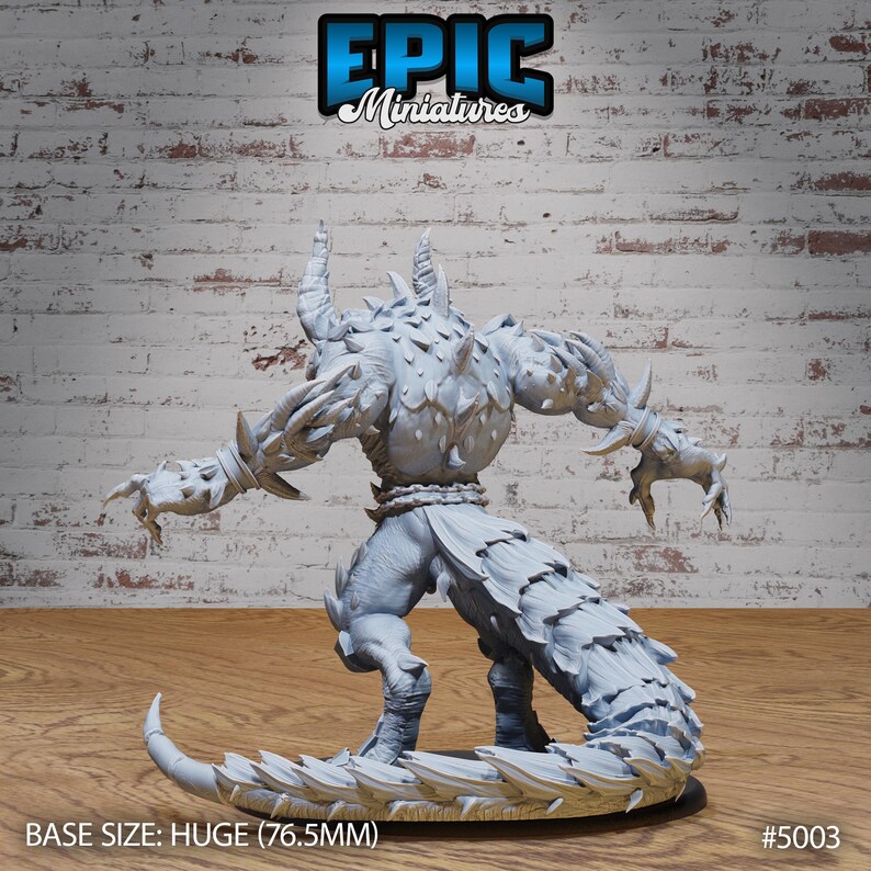 May include: A gray, detailed miniature of a monstrous creature with horns, spikes, and a long, scaly tail. The miniature is posed in a dynamic stance, with its arms outstretched and its tail curled around its legs. The base of the miniature is a circular, textured surface. The miniature is labeled "#5003" and "BASE SIZE: HUGE (76.5MM)".