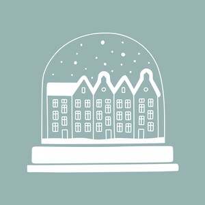 May include: A white snow globe with a row of houses inside. The snow globe is on a blue background.