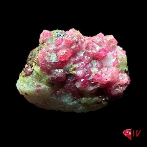May include: A cluster of pink ruby crystals with a green and gold matrix. The crystals are sharp and well-defined, with a high luster. This is a beautiful example of a ruby specimen.
