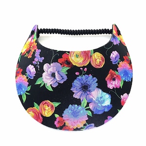 May include: A black visor with a floral print featuring colourful flowers on a black background. The visor has a black elastic band.