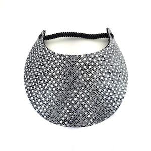 May include: A black visor with a silver glitter polka dot pattern. The visor has an elastic band for a comfortable fit.