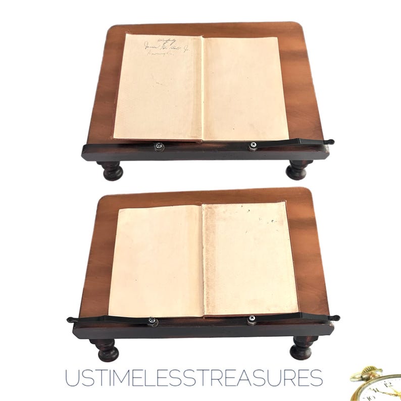 May include: Two wooden book stands with a dark brown finish. Each stand holds an open book with aged, cream-colored pages. The stands have a sloped design and are supported by four rounded legs. The text "USTIMELESSTREASURES" is at the bottom.