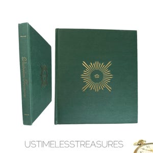May include: Two green hardcover books. The book on the left has the title "Victorian Treasures" printed vertically in gold. The book on the right has a gold sunburst design. The books are on a white background.