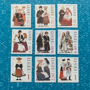 Könnte beinhalten: Neun estnische Briefmarken mit Abbildungen von Menschen in traditioneller Kleidung. Jede Marke trägt das Wort „EESTI“ und einen Preis. Die Marken zeigen verschiedene regionale Trachten, vor blauem Hintergrund. Maße in cm.