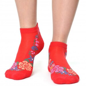 May include: Red ankle socks with a floral design. The flowers are pink, blue, and green.