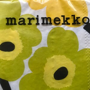 May include: A package of Marimekko brand paper napkins. The napkins feature a repeating floral pattern in shades of yellow and green on a white background. The word "marimekko" is printed in black block letters.