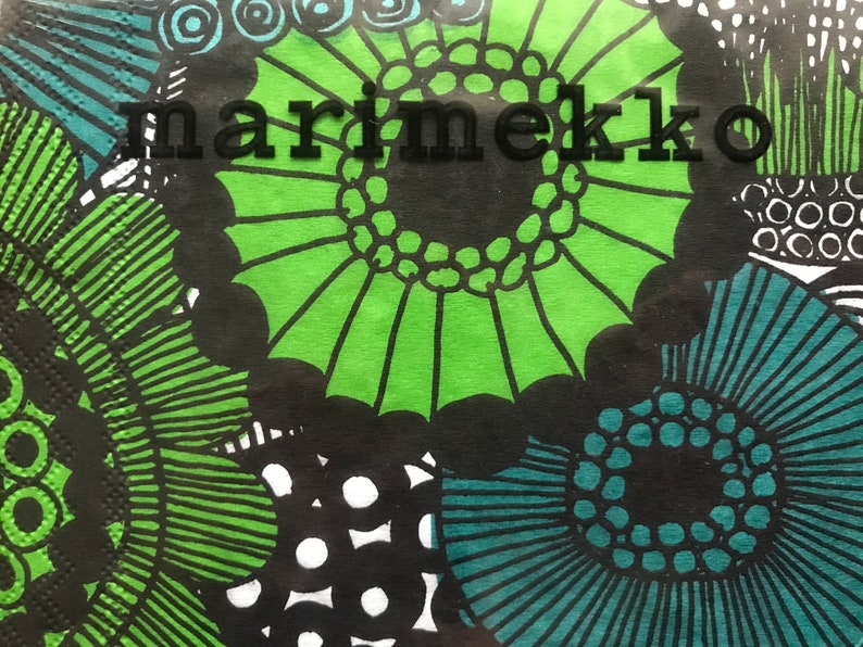 May include: Close-up of a patterned design featuring large, stylized floral shapes in green, teal, and black. The word "marimekko" is printed in black across the top of the image. The design is bold and graphic.