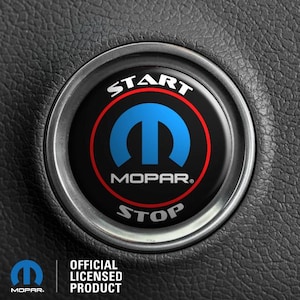 Peut inclure: Un bouton de démarrage de voiture noir et rouge avec le mot "START" en blanc au-dessus du logo Mopar et le mot "STOP" en blanc en dessous du logo.
