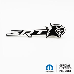 May include: A black and white SRT emblem featuring a stylized eagle head. The emblem has the letters "SRT" in white, with a black background. The eagle head is on the right side of the emblem.