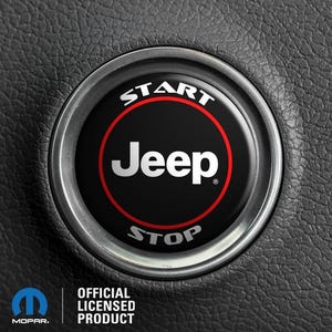 May include: A black and red Jeep start stop button with the words "START" and "STOP" in white lettering around the edge of the button. The Jeep logo is in the center of the button in white lettering.