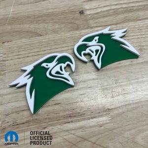 May include: Two green and white eagle head decals. The decals are made of a thick, durable material and have a white outline. The decals are perfect for adding a touch of style to your car or truck.