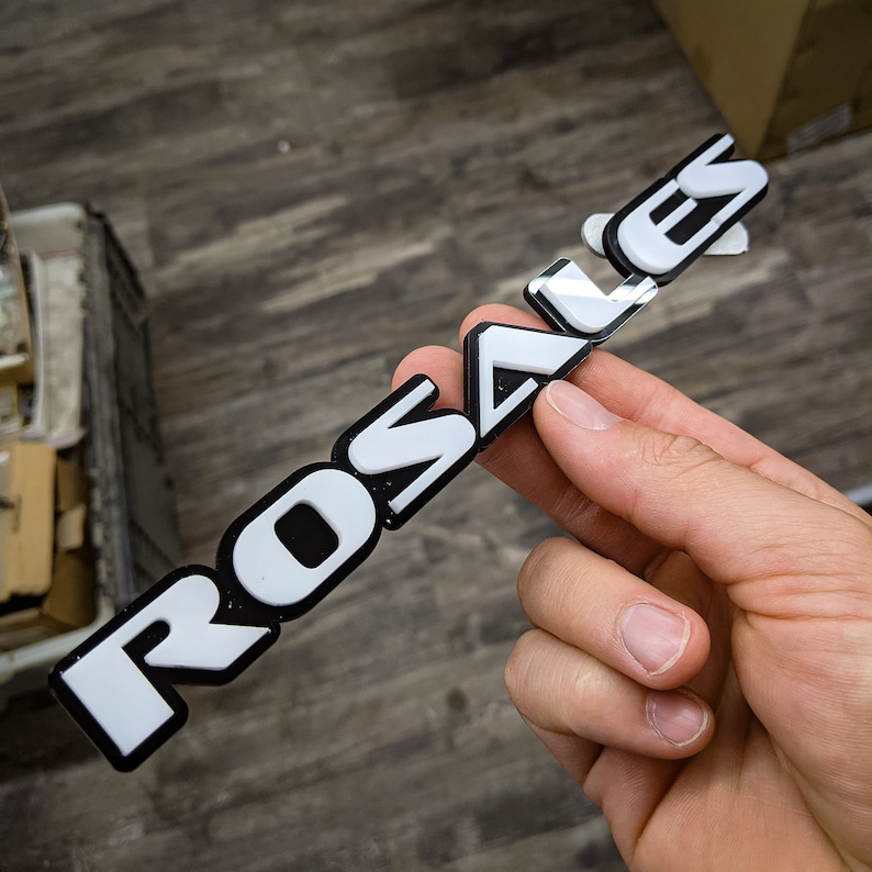 May include: White plastic emblem with the word "ROSALES" in black lettering.