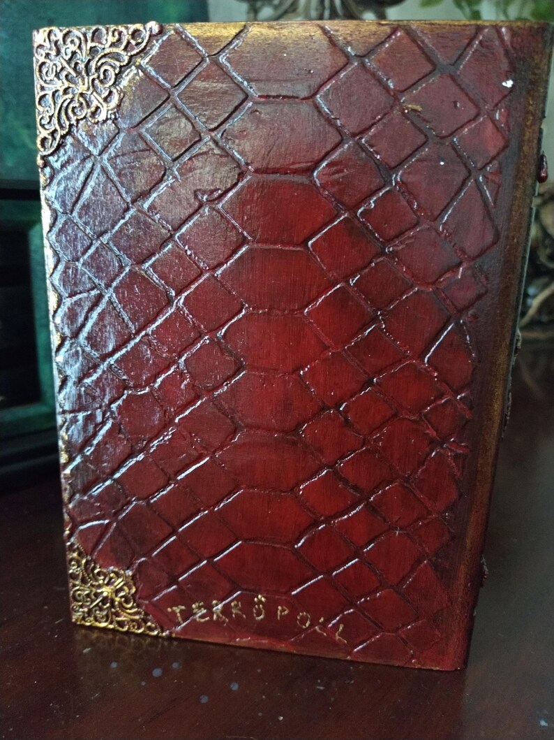 May include: A red leather-bound book with a gold embossed design and the text "TERROR POLL" on the bottom edge.