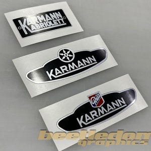 Może przedstawiać: Trzy srebrne i czarne naklejki samochodowe z napisem "Karmann". Jedna naklejka zawiera napis "Karmann Cabriolet". Inna naklejka przedstawia stylizowane koło z czterema szprychami. Trzecia naklejka zawiera napis "Ghia" w kolorze czerwonym i niebieskim.