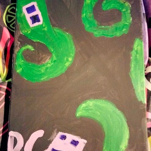 May include: Abstract painting on canvas with a dark gray background. The artwork features green, swirling shapes and two light purple structures with dark blue square details. The letters "DC" are visible in white.